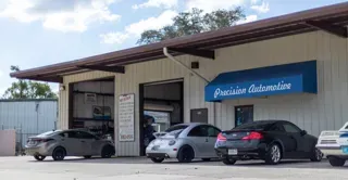 Precision Automotive exterior — navy awning and bay doors at 268 E. Palmetto Ave, Longwood FL